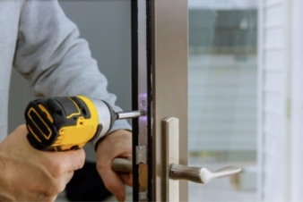 Technician repairing a hollow metal door in a Grand Junction commercial building