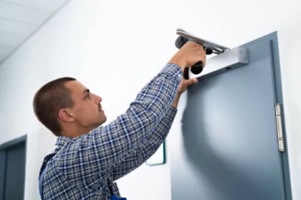 Technician adjusting door closer to fix door slamming in Grand Junction