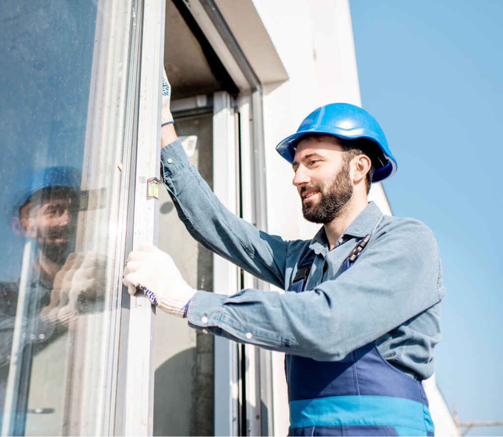Professional technician measuring and installing custom cut window glass in Grand Junction Colorado.