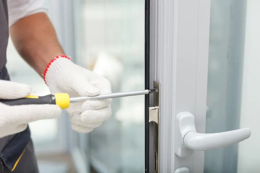 Professional technician repairing a commercial glass and aluminum door in Rifle, Colorado.