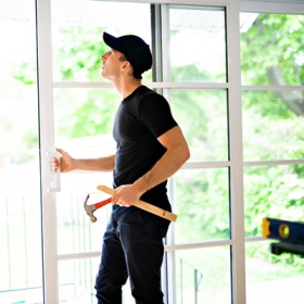 : Professional technician repairing a commercial glass entry door in Glenwood Springs, Colorado.