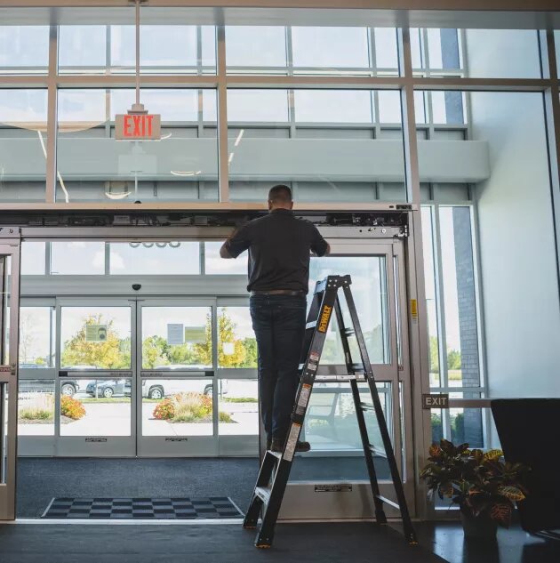 Technician inspecting an automatic commercial door that is staying open in Glenwood Springs, Colorado.
