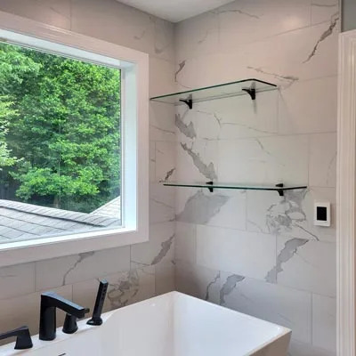 Custom glass shelf installed inside a modern shower in Grand Junction, Colorado.