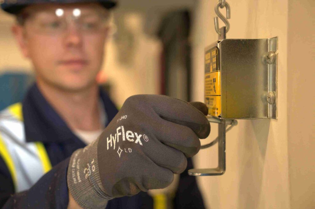 Technician repairing a commercial automatic door opener button at a business in Glenwood Springs, Colorado.