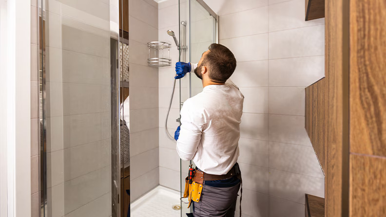 Professional technician repairing a dragging glass shower door in Glenwood Springs, Colorado.