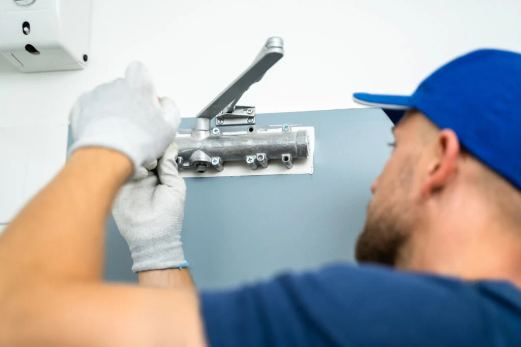 Technician inspecting an automatic commercial door opener at a business in Grand Junction, Colorado.
