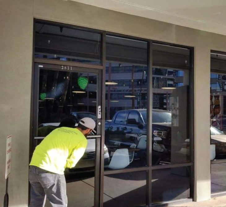 Professional glass technician repairing commercial storefront glass in Grand Junction, Colorado.