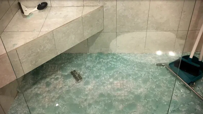 Shattered tempered glass shower door requiring professional replacement in Grand Junction, Colorado.